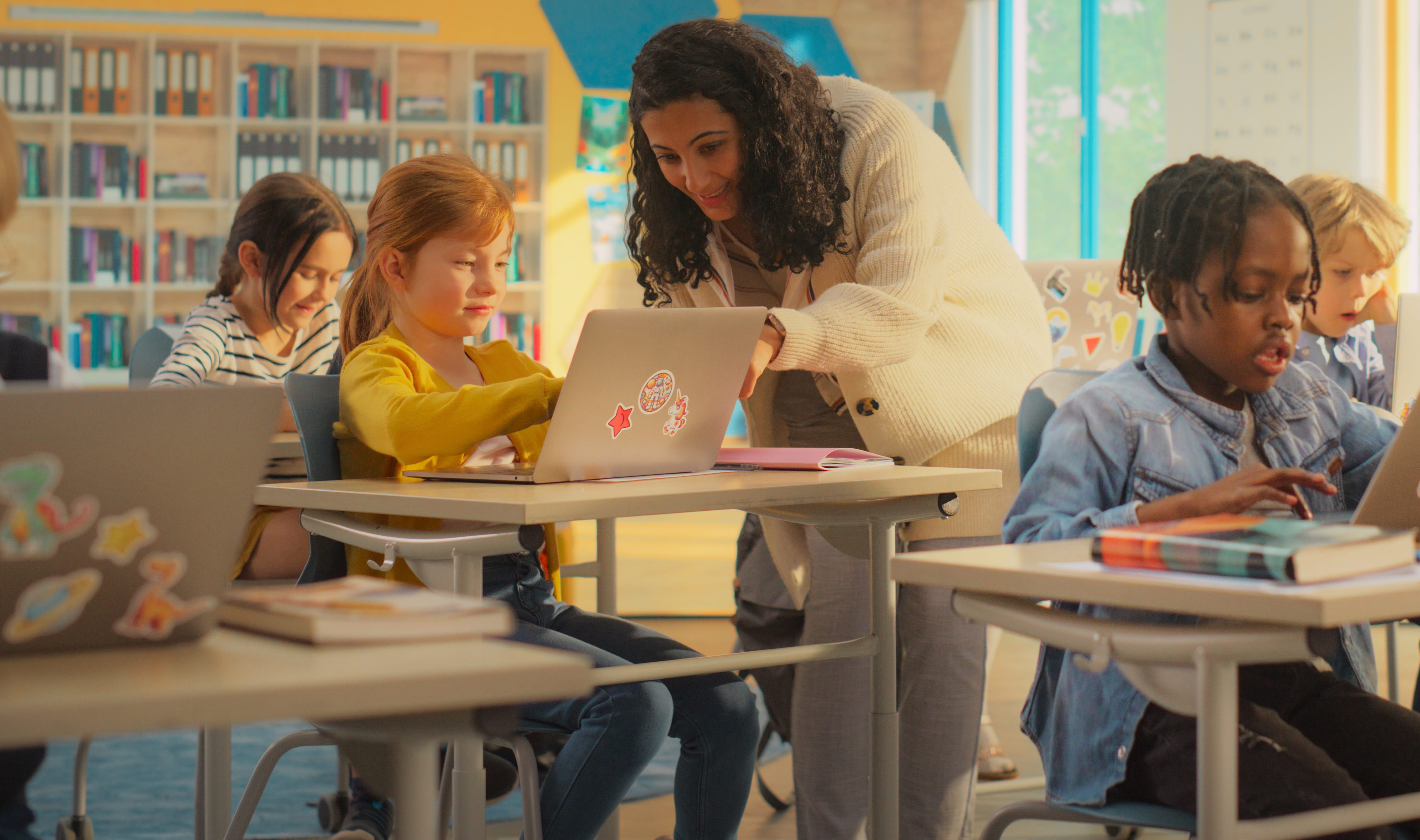 Students typing in classroom with teacher